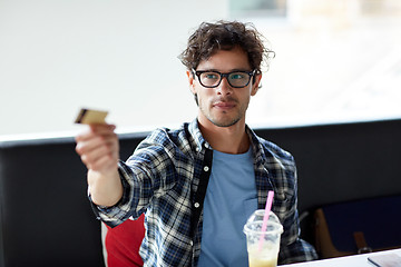 Image showing happy man paying with credit card at cafe