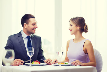 Image showing smiling couple eating main course at restaurant