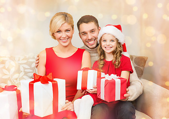 Image showing smiling family holding many gift boxes