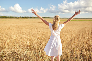 Image showing happy young woman in white dress on cereal field