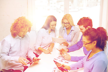 Image showing smiling team with table pc and papers working