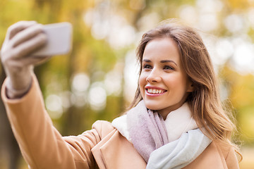 Image showing woman taking selfie by smartphone in autumn park