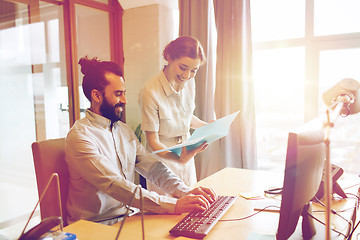 Image showing happy creative team with computer in office