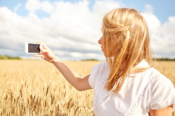 Image showing close up of girl with smartphone on cereal field