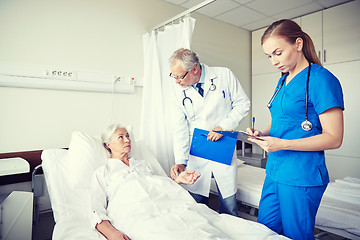 Image showing doctor and nurse visiting senior woman at hospital