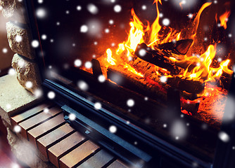 Image showing close up of burning fireplace with snow