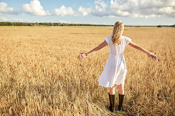 Image showing happy young woman in white dress on cereal field