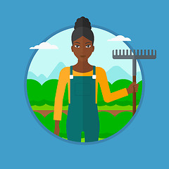 Image showing Farmer with rake at cabbage field.