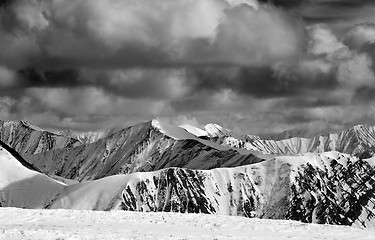 Image showing Black and white winter snow mountains in storm clouds