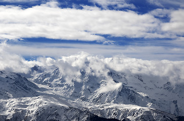 Image showing Snow winter mountains in clouds at sun day