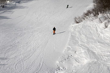 Image showing Skiers on ski slope at sun winter day