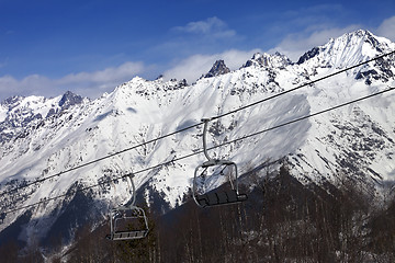 Image showing Ski resort with chair lift and snow mountains at nice sunny day