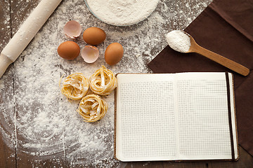 Image showing Cooking some tasty food and writing down recipe.