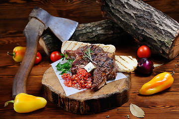 Image showing juicy steak on the wooden background