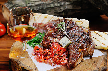 Image showing juicy steak on the wooden background