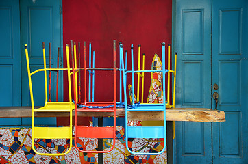 Image showing Colorful chairs on a wooden table 