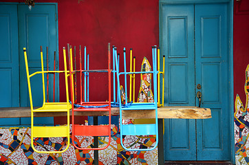 Image showing Colorful chairs on a wooden table