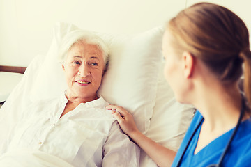 Image showing doctor or nurse visiting senior woman at hospital