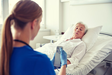 Image showing doctor or nurse visiting senior woman at hospital