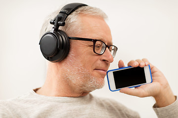 Image showing happy senior man with smartphone and headphones