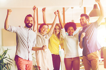 Image showing happy creative team celebrating victory in office