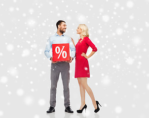 Image showing happy couple with red sale sign over snow