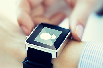 Image showing close up of hands with message icon on smartwatch