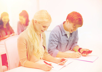 Image showing smiling students with notebooks at school