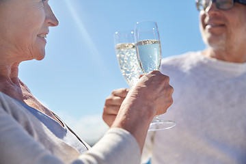 Image showing happy senior couple drinking champagne outdoors