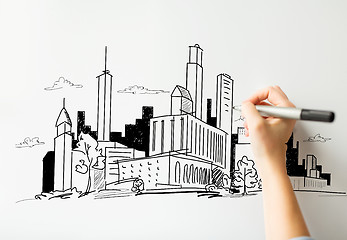 Image showing close up of hand drawing city on white board