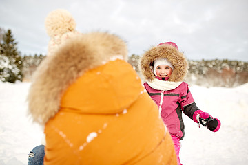 Image showing happy family in winter clothes playing outdoors