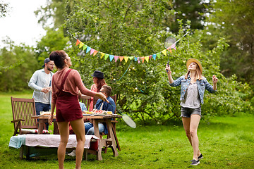 Image showing happy friends playing badminton at summer garden