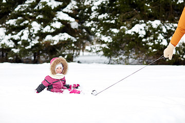 Image showing happy little kid riding on sled outdoors in winter