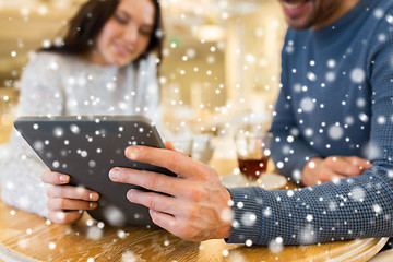 Image showing happy couple with tablet pc drinking tea at cafe