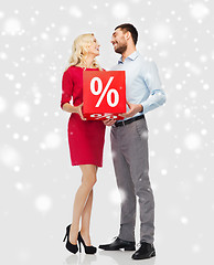 Image showing happy couple with red sale sign over snow