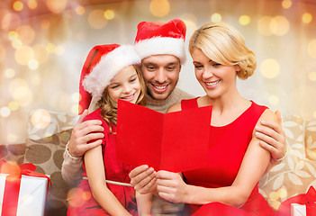 Image showing smiling family reading postcard