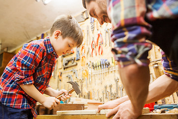 Image showing father and son with hammer working at workshop