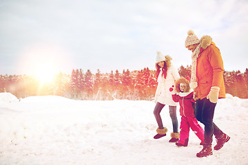 Image showing happy family in winter clothes walking outdoors