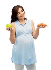 Image showing happy pregnant woman with apple and croissant