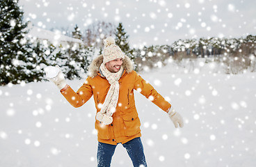 Image showing happy young man playing snowballs in winter