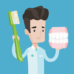 Image showing Dentist with dental jaw model and toothbrush.