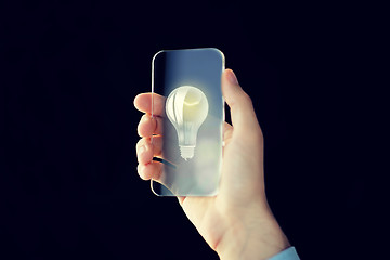 Image showing close up of male hand with transparent smartphone