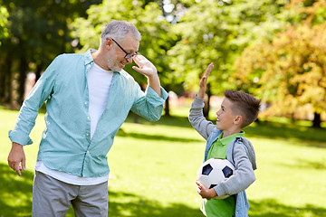 Image showing old man and boy with soccer ball making high five