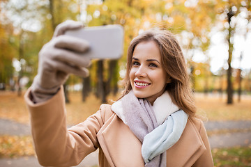 Image showing woman taking selfie by smartphone in autumn park