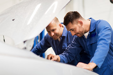 Image showing mechanic men with wrench repairing car at workshop