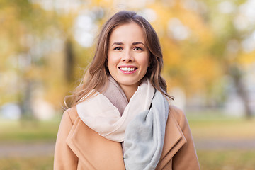 Image showing beautiful happy young woman smiling in autumn park