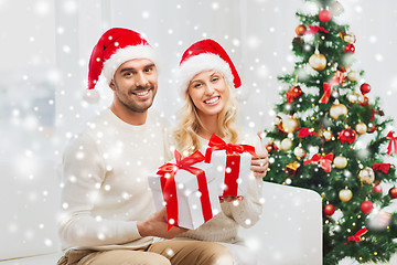 Image showing happy couple at home with christmas gift boxes