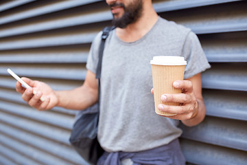 Image showing man with coffee texting on smartphone in city