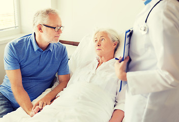 Image showing senior woman and doctor with clipboard at hospital