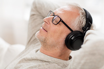 Image showing happy man in headphones listening to music at home